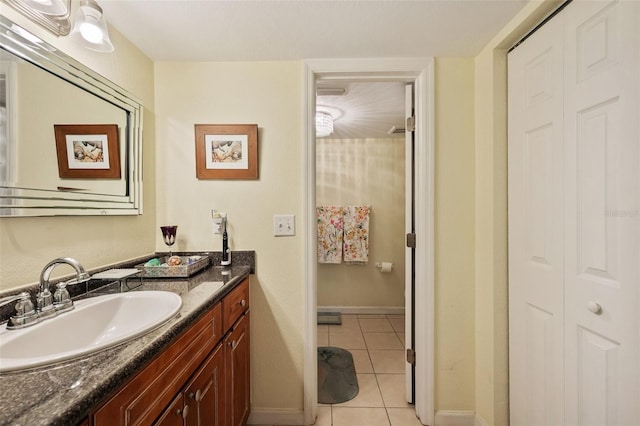 bathroom featuring tile patterned flooring, baseboards, and vanity