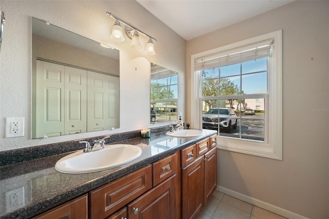 full bathroom with tile patterned floors, a sink, baseboards, and double vanity