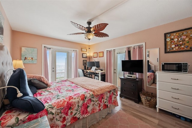 bedroom with access to outside, light wood-type flooring, and a ceiling fan