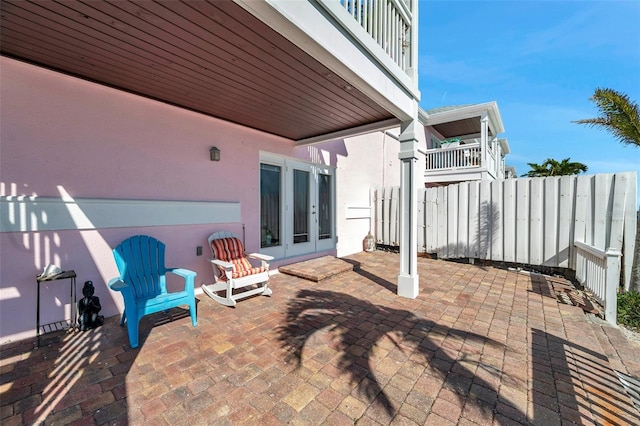 view of patio with french doors and fence