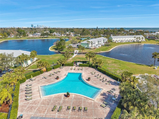 community pool with a patio area and a water view