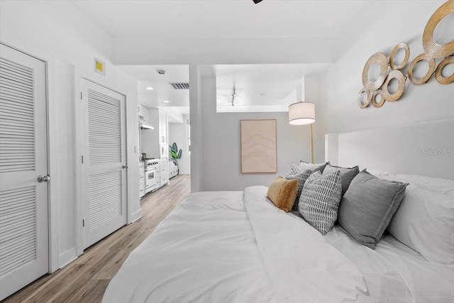 bedroom with light wood-type flooring and visible vents