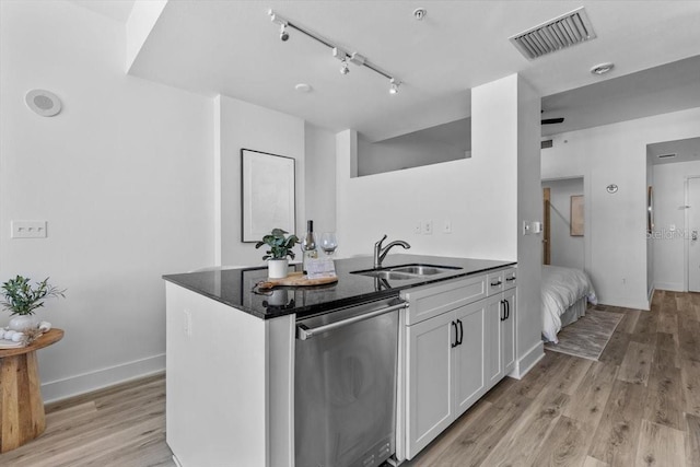 kitchen with a sink, visible vents, light wood-style floors, white cabinetry, and dishwasher