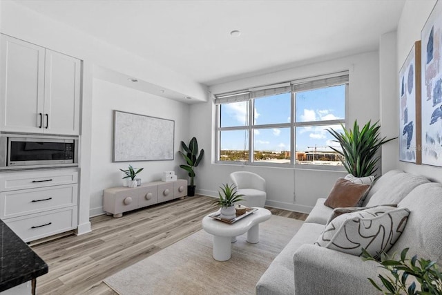 living area featuring light wood-type flooring and baseboards