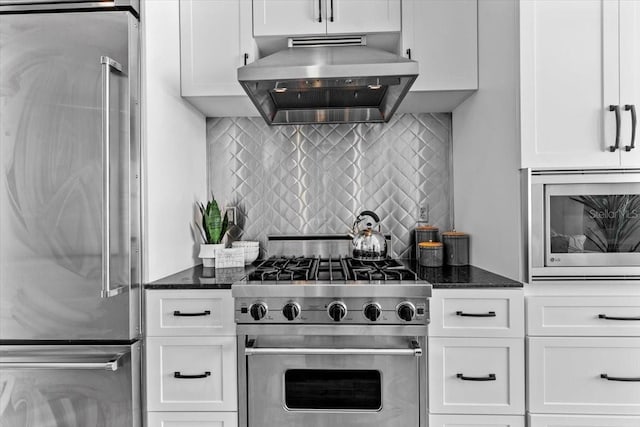 kitchen featuring tasteful backsplash, high end appliances, dark stone countertops, ventilation hood, and white cabinetry