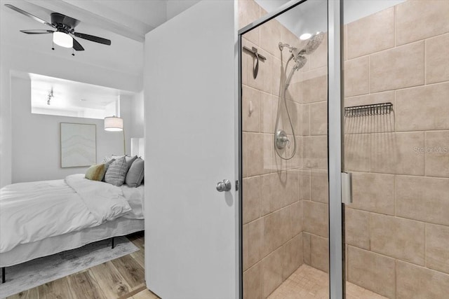 ensuite bathroom featuring wood finished floors, ensuite bath, a ceiling fan, and a shower stall