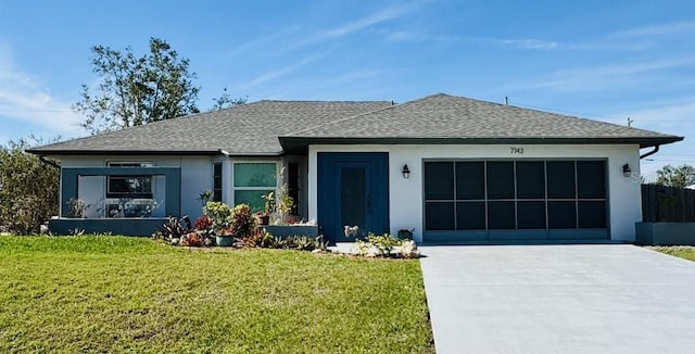 view of front facade with an attached garage, a shingled roof, and a front lawn