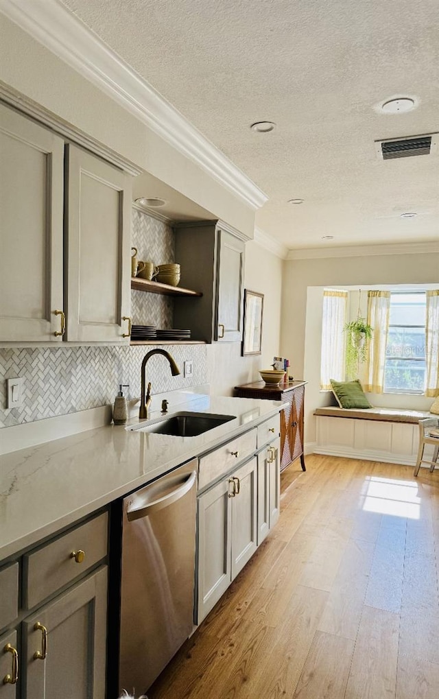 kitchen with tasteful backsplash, dishwasher, gray cabinets, crown molding, and a sink