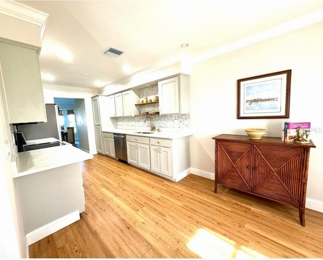 kitchen with visible vents, light countertops, stainless steel dishwasher, open shelves, and a sink