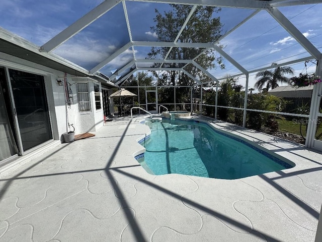 view of swimming pool featuring glass enclosure, a patio area, and a pool with connected hot tub