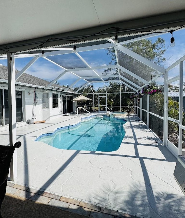 pool featuring glass enclosure and a patio