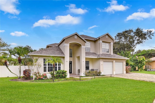 traditional-style home featuring decorative driveway, stucco siding, an attached garage, fence, and a front lawn