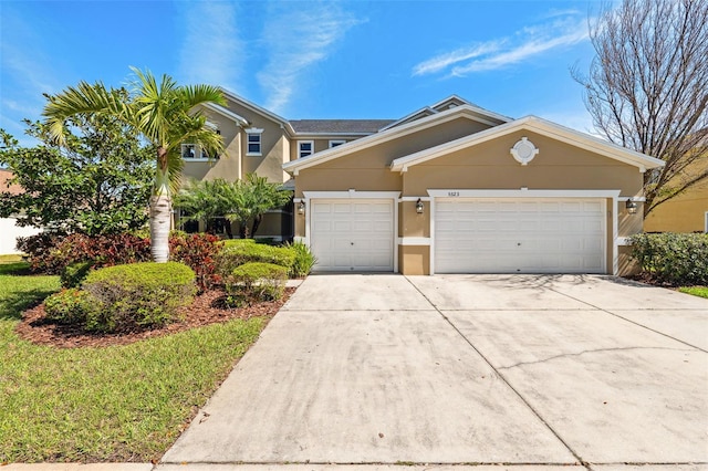 view of front facade with a garage, concrete driveway, and stucco siding