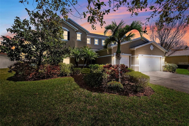 view of front of property with a front lawn, driveway, an attached garage, and stucco siding