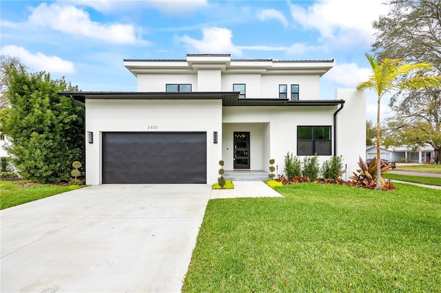 view of front facade with a garage, a front yard, concrete driveway, and stucco siding