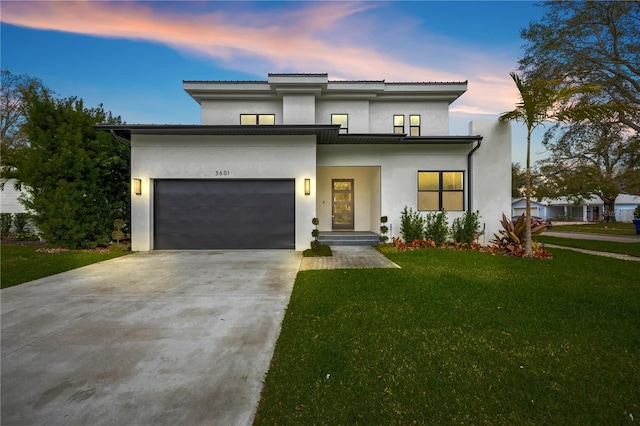 view of front of home featuring a garage, driveway, a front lawn, and stucco siding