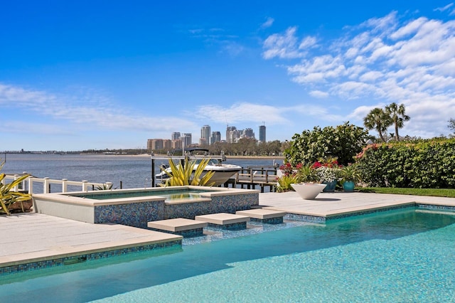 pool with a water view, a boat dock, a patio, and an in ground hot tub