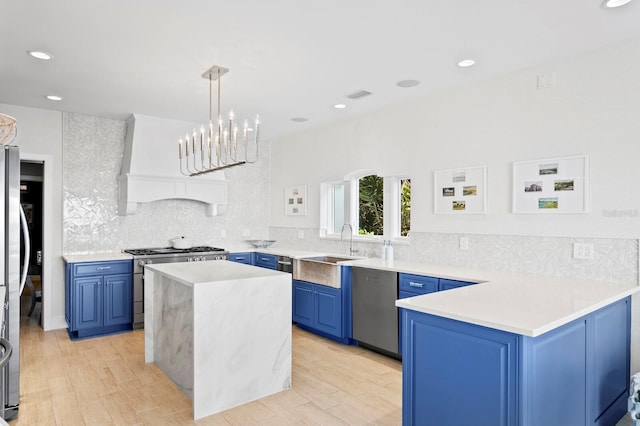 611 Brightwaters Blvd NE, Saint Petersburg, FL 33704 - kitchen featuring light countertops, blue cabinetry, appliances with stainless steel finishes, backsplash, and light wood finished floors