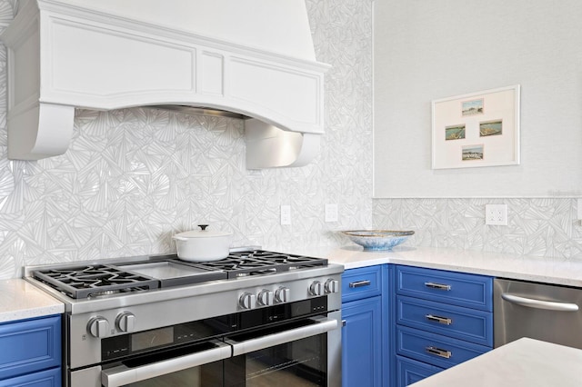 611 Brightwaters Blvd NE, Saint Petersburg, FL 33704 - kitchen with stainless steel appliances, blue cabinetry, light countertops, and tasteful backsplash
