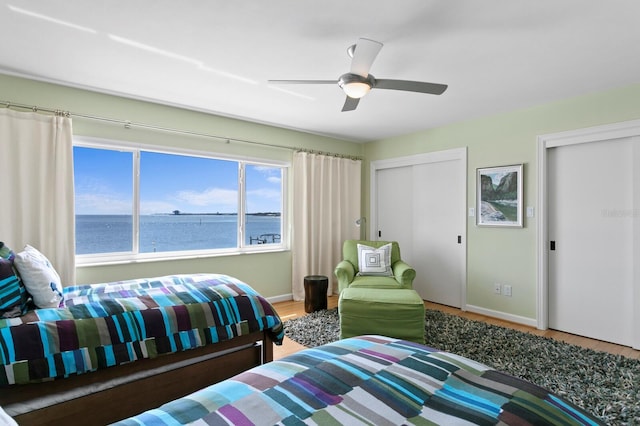 611 Brightwaters Blvd NE, Saint Petersburg, FL 33704 - bedroom with a water view, ceiling fan, baseboards, and wood finished floors
