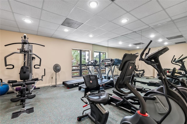 exercise room with a drop ceiling and baseboards