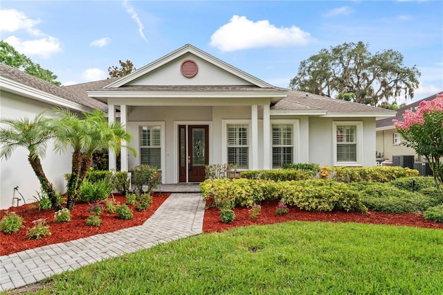 view of front of home featuring a front lawn, a porch, a shingled roof, and stucco siding