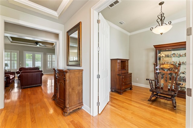 hall featuring light wood-type flooring, visible vents, and crown molding