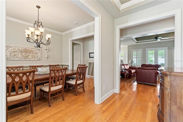 dining space with crown molding, visible vents, light wood-style floors, baseboards, and ceiling fan with notable chandelier