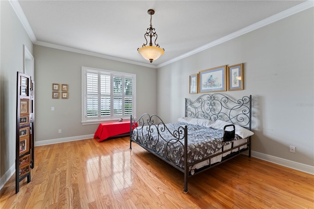 bedroom with crown molding, baseboards, and light wood-style floors