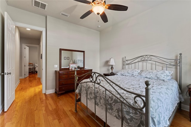 bedroom with light wood-type flooring, baseboards, and visible vents