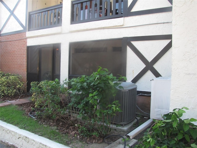 exterior details with stucco siding and central AC unit