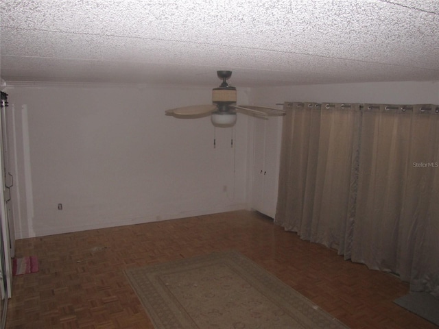 empty room with ceiling fan and a textured ceiling