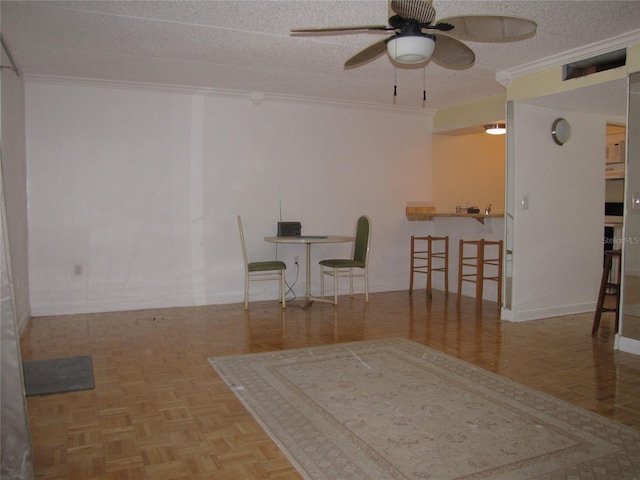 unfurnished dining area featuring a textured ceiling, a ceiling fan, and crown molding