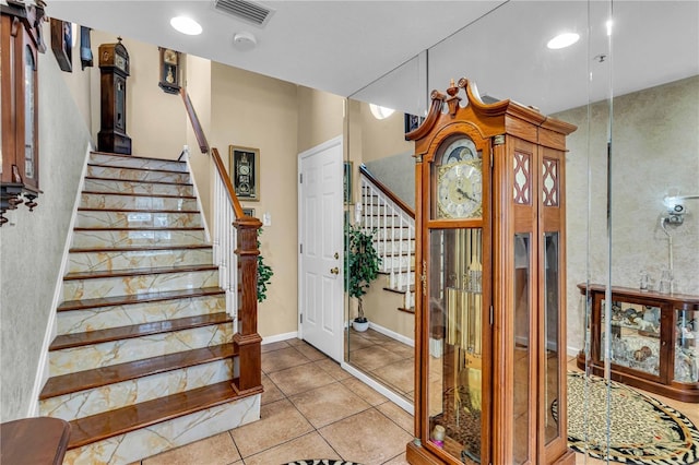 stairway featuring tile patterned flooring and visible vents