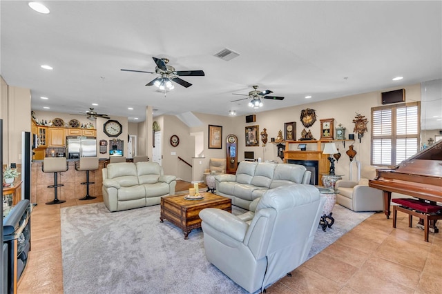 living room featuring recessed lighting, visible vents, a fireplace, and light tile patterned floors