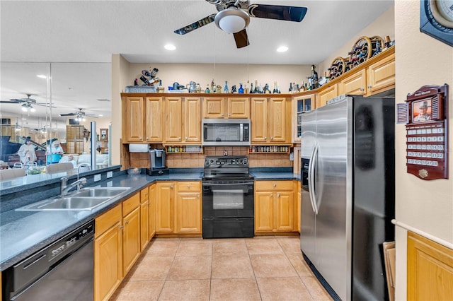 kitchen with light tile patterned flooring, a sink, backsplash, black appliances, and dark countertops