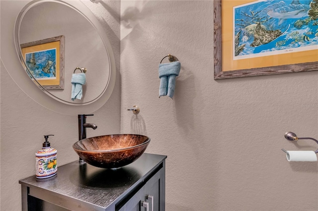 bathroom featuring a textured wall and vanity