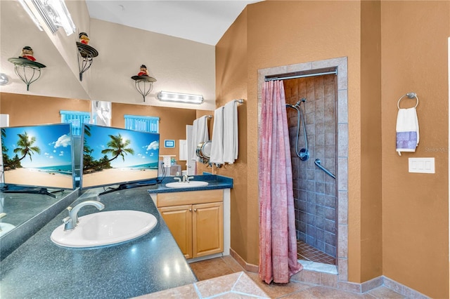 bathroom featuring double vanity, a stall shower, and a sink