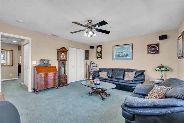 carpeted living room featuring ceiling fan, visible vents, and baseboards