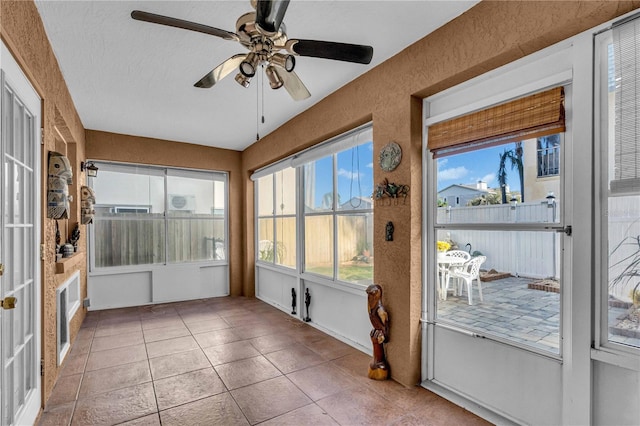 unfurnished sunroom featuring ceiling fan