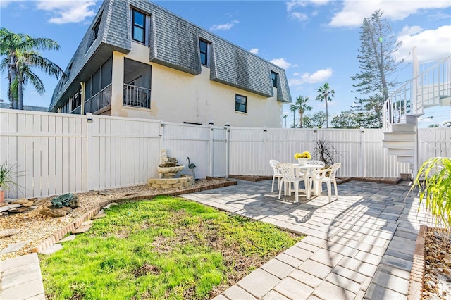 view of yard with a fenced backyard, a patio, and stairway