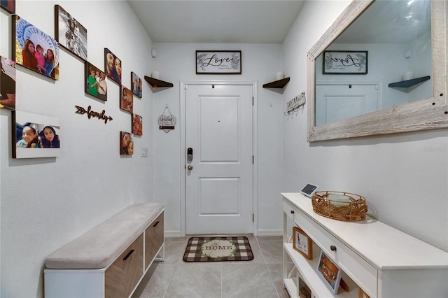 mudroom with light tile patterned floors and baseboards