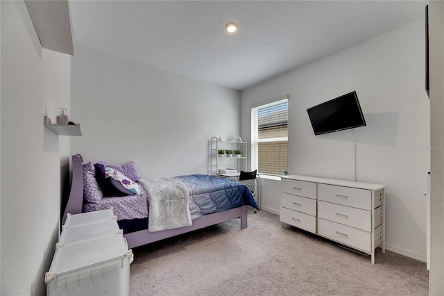 bedroom with light carpet and baseboards