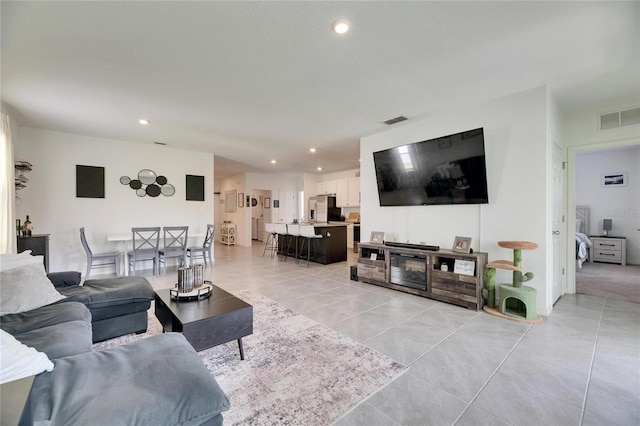 living area with light tile patterned floors, visible vents, and recessed lighting