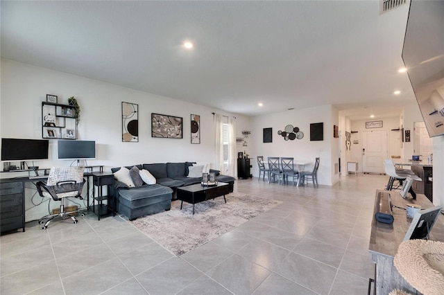 living area with light tile patterned floors, recessed lighting, visible vents, and built in study area