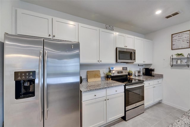 kitchen with stainless steel appliances, white cabinets, and visible vents