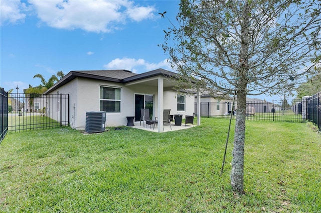 back of property with a patio, central air condition unit, stucco siding, a lawn, and a fenced backyard