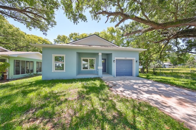 ranch-style home with driveway, a front lawn, an attached garage, and stucco siding