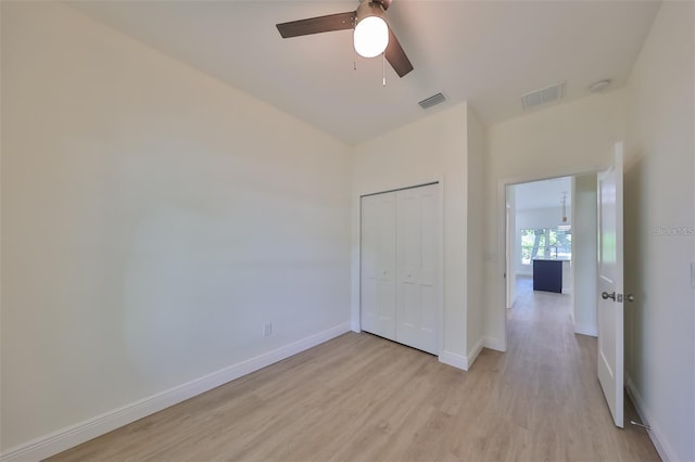 unfurnished bedroom featuring light wood finished floors, a closet, visible vents, and baseboards