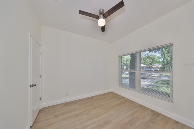 spare room featuring light wood-type flooring, ceiling fan, and baseboards